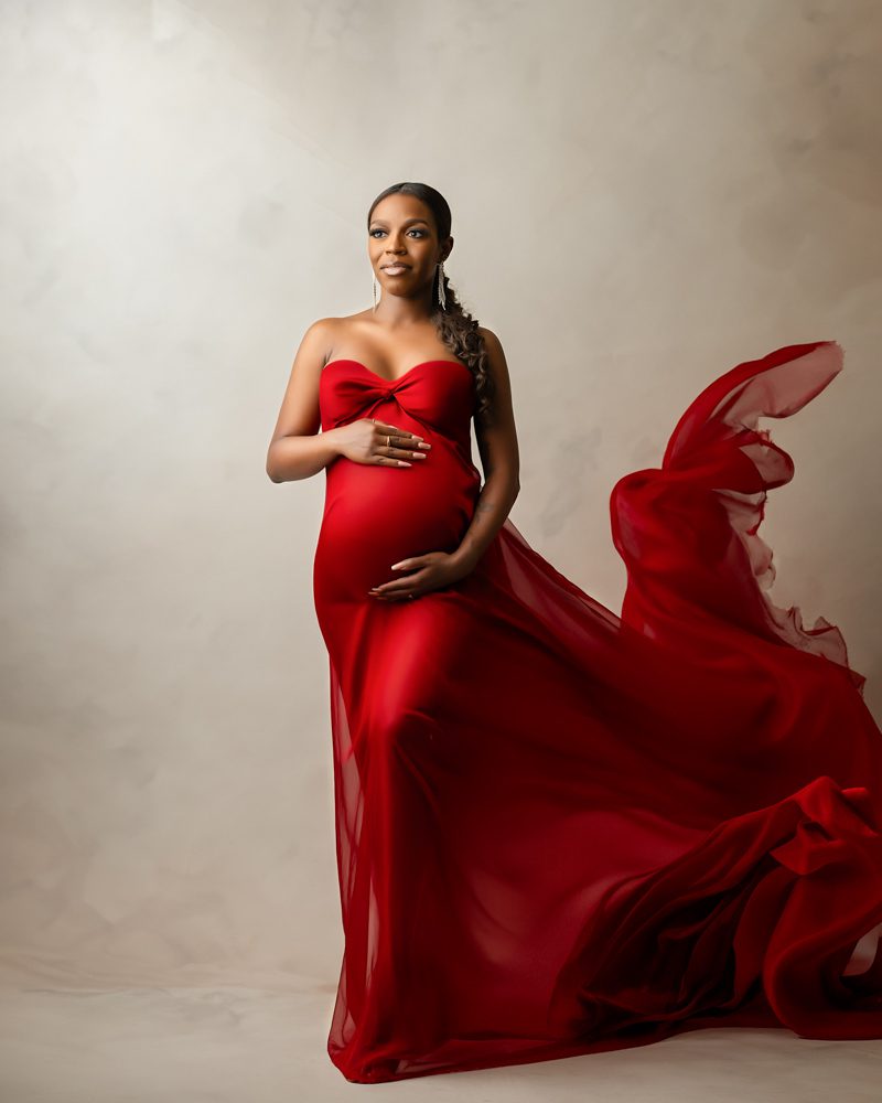 fine art maternity photos dallas woman in a red gown posing elegantly